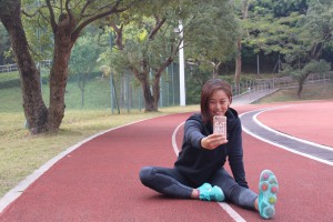 Christine Fung Hiu-tung takes a selfie while doing her stretching exercises.